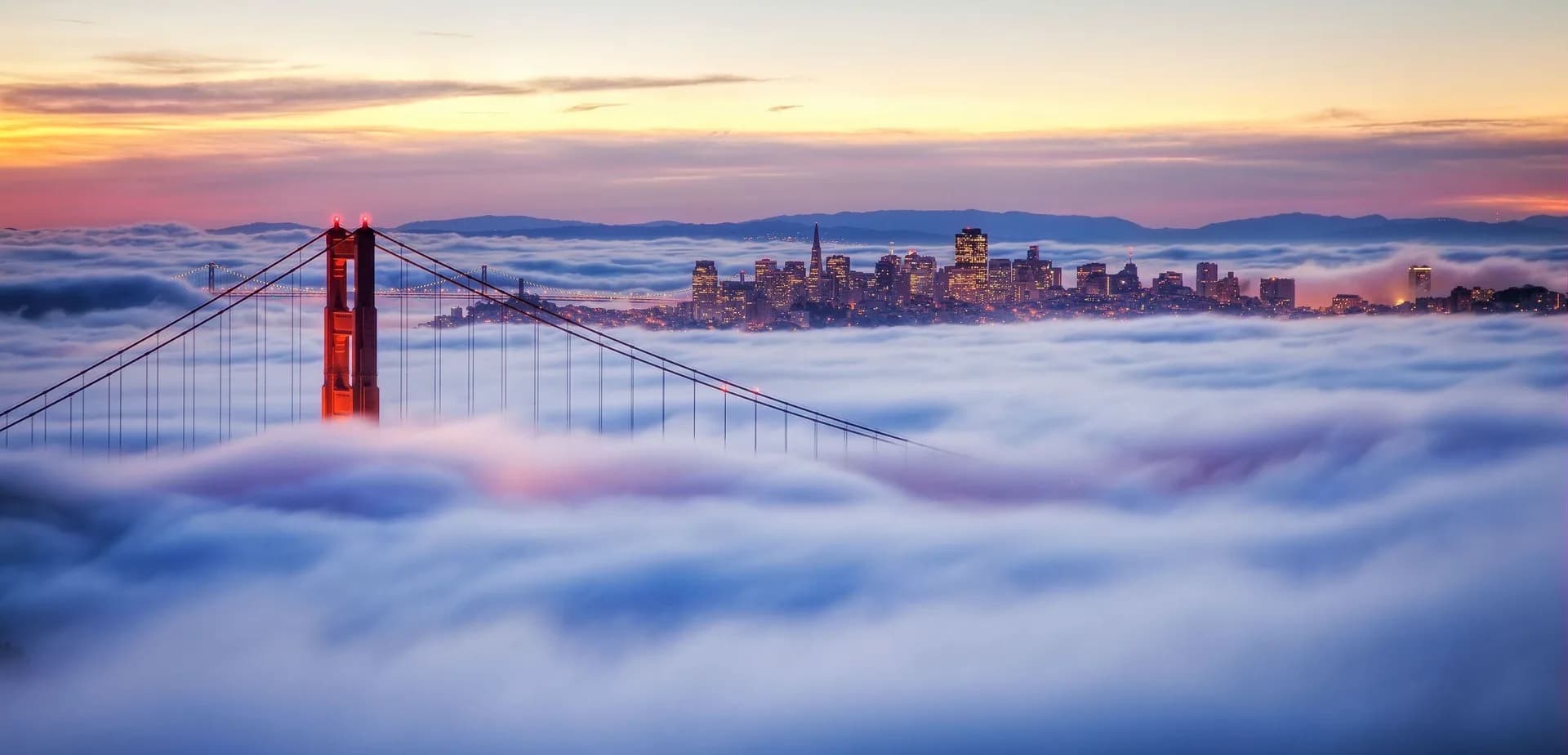 San Francisco skyline and Golden Gate Bridge surrounded by fog